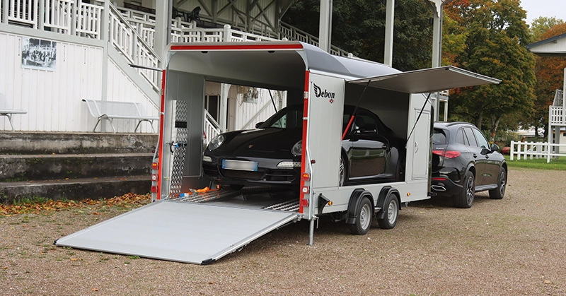 Sports car loaded inside an enclosed covered trailer transporter